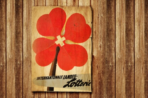 Logo original de la Loterie intercantonale - le trèfle rouge à quatre feuilles avec la croix suisse Ursprungslogo der Interkantonalen Landeslotterie - rotes Kleeblatt mit Schweizer Kreuz. Logo original de la Loterie intercantonale - le trèfle rouge à quatre feuilles avec la croix suisse. Logo originale della Lotteria Intercantonale - quadrifoglio rosso con la croce svizzera.